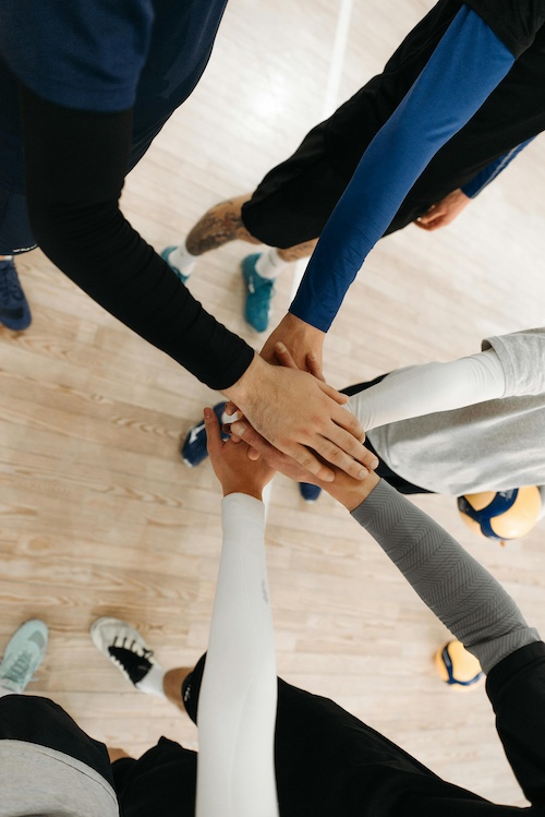 a group of people putting their hands together